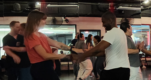 West Coast Swing dancers demonstrating a Left Side Pass and Right-Side Pass on the dance floor