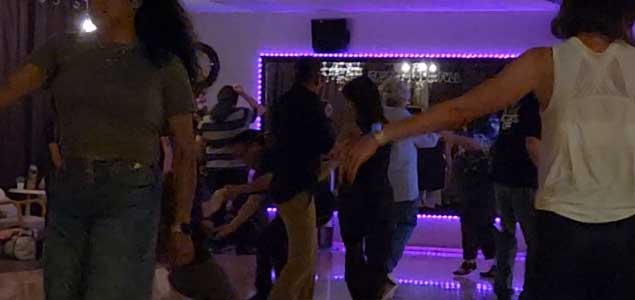 West Coast Swing partners practicing a basic step on the social dance floor.